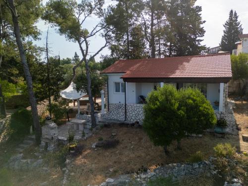 a small white cottage with a red roof at Villa Pinus in Stari Grad