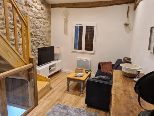 Una sala de estar con un sofá y un televisor. en Gite cap de biou, en Penne