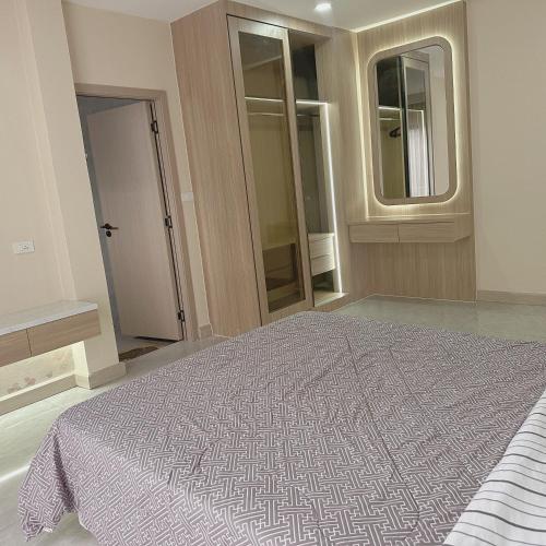 a bedroom with a large bed and a mirror at Eakmongkol Luxury Five-Bedroom Pool Villa in Jomtien Beach
