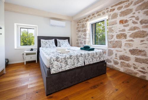 a bedroom with a large bed in a brick wall at Haus Meter in Donji Proložac - Haus für 6 Personen in Donji Proložac