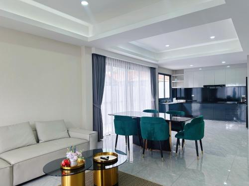 a living room with a couch and a table at Eakmongkol Luxury Five-Bedroom Pool Villa in Jomtien Beach