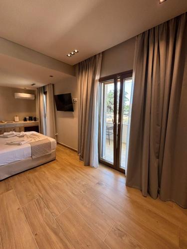 a bedroom with a bed and a sliding glass door at ΝΕΑΚΙΤΟΣ Luxury Apartments in Nikiti