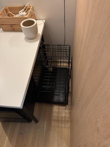 a black dog crate sitting on top of a white table at Cozy Ozo Park Apartment, Pet Friendly with Workspace in Vilnius