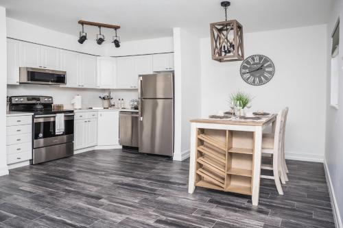 Una cocina con mesa y electrodomésticos de acero inoxidable. en Location! Quality! Comfort! The downtown Gem, en Naples