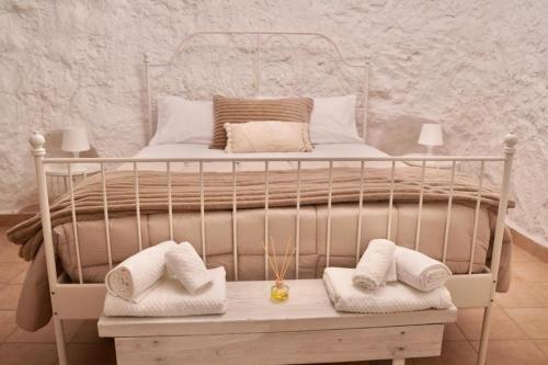 a white bed with towels on a wooden table at Affittacamere Casa nella grotta in Laterza