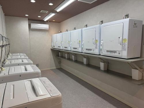 a row of white machines on shelves in a room at Sakura Terrace The Gallery in Kyoto