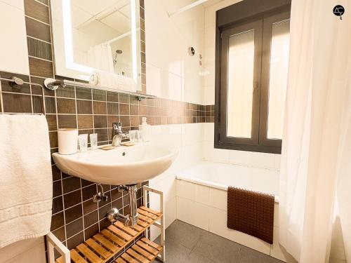 biała łazienka z umywalką i wanną w obiekcie URBAN BEACH Grupo AC Gestion w Kadyksie