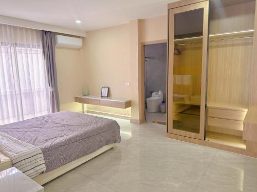 a bedroom with a bed and a bathroom with a toilet at Eakmongkol Luxury Five-Bedroom Pool Villa in Jomtien Beach
