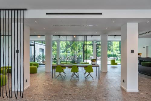 a lobby with a table and green chairs at Hotel Royal Village in Limone sul Garda