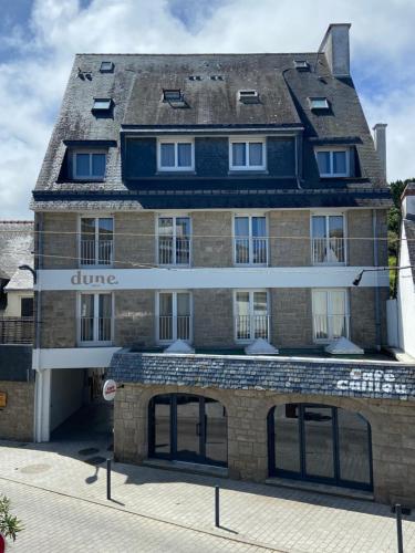 a large brick building with a sign that reads dune at Hôtel Dune Saint-Pierre in Saint-Pierre-Quiberon