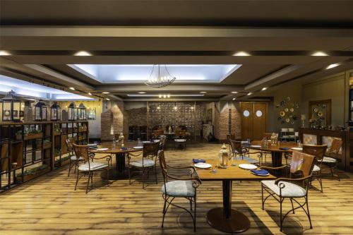 a restaurant with tables and chairs in a room at Radisson Blu Hotel Pune Kharadi in Pune