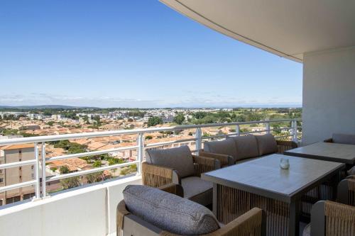 a balcony with a table and chairs and a view at Valras-Loc Panarea Duplex avec vue mer, spa in Valras-Plage