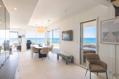 a living room with a dining table and a view of the ocean at Valras-Loc Panarea Duplex avec vue mer, spa in Valras-Plage