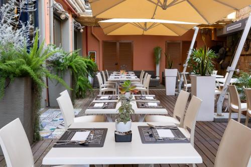 an outdoor restaurant with white tables and chairs at Grand Hotel Tiberio in Rome