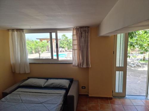 ein Schlafzimmer mit einem Bett und einem großen Fenster in der Unterkunft Villa Dei Santi, Taverna in Santa Maria di Castellabate