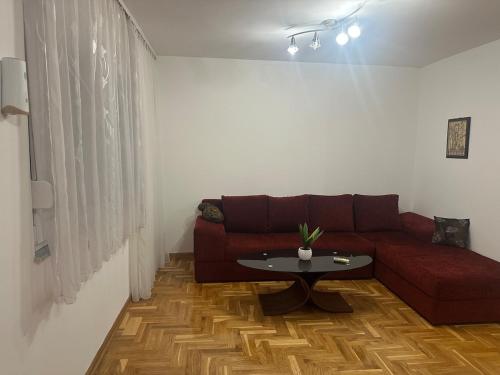 a living room with a red couch and a table at Apartments Naresi Mostar in Mostar
