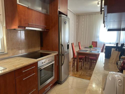a kitchen with a stainless steel refrigerator and a table at Apartments Naresi Mostar in Mostar