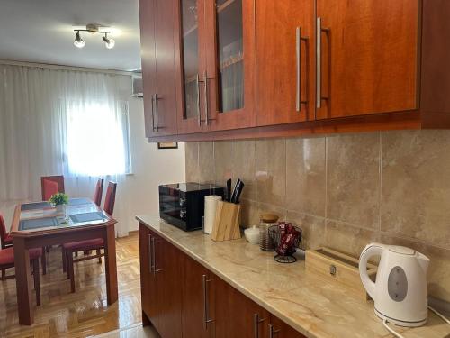 a kitchen with wooden cabinets and a counter top at Apartments Naresi Mostar in Mostar