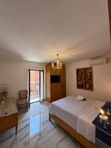 a bedroom with a bed and a table and a chandelier at Kapo Azzurro in Monterotondo