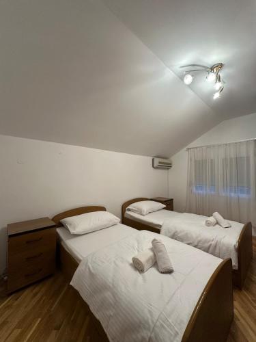 a room with two beds with towels on them at Apartments Naresi Mostar in Mostar