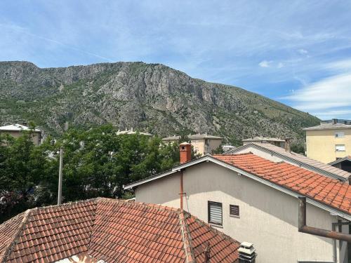 a mountain in the distance with houses and roofs at Apartments Naresi Mostar in Mostar