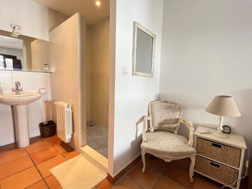 a bathroom with a chair and a sink at Maison de village avec roof top in Adsubia