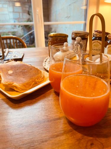 リブルヌにあるLes Chambres de Sophieのオレンジジュースと食器一皿