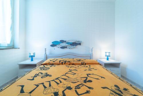 a bedroom with a bed with a bedspread with animals on it at La Casa della Riviera in Platamona