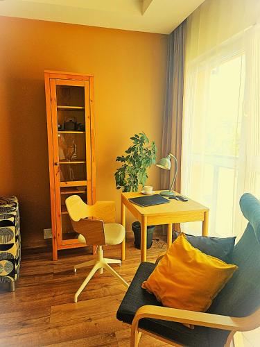 a living room with a desk and a table and a chair at Apartament Garbary22 in Bydgoszcz