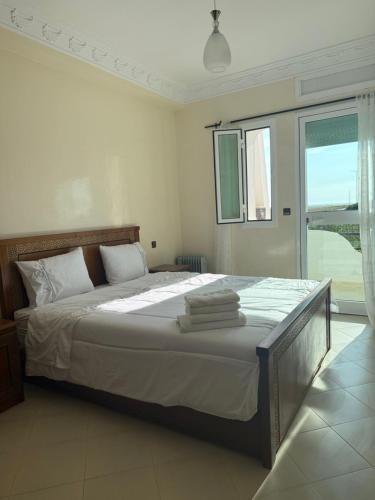 a bedroom with a large bed with towels on it at Apparemment Achakar in Tangier