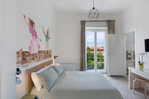 a white bedroom with a bed and a desk at Grimaldi Rooms in Pagani