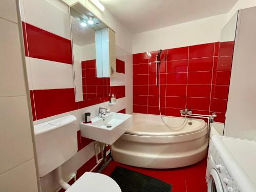 a red and white bathroom with a toilet and a sink at Sea & Stay in Constanţa