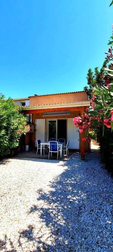 une maison avec un patio avec une table et des chaises dans l'établissement Havre de paix a Vendres-Plage, maison avec jardin et piscine, à Vendres
