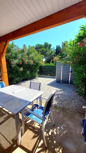 - une table de pique-nique et des chaises sur la terrasse dans l'établissement Havre de paix a Vendres-Plage, maison avec jardin et piscine, à Vendres