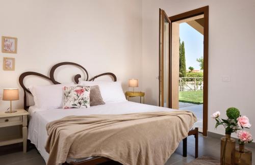 a bedroom with a bed with white sheets and flowers at Borgo Verde in Vada