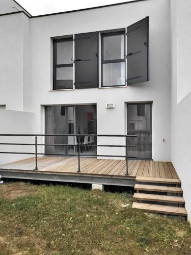 une maison blanche avec une terrasse en bois dans l'établissement ROY ld70, à Sérignan