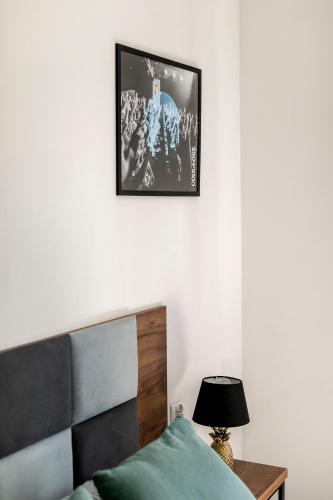 a bedroom with a bed and a picture on the wall at Cooltour Hostel in Poznań