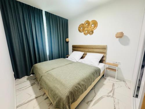 a bedroom with a large bed with green curtains at Rodzinny Apartament przy plaży, Bezpłatny parking Dąbki in Dąbki