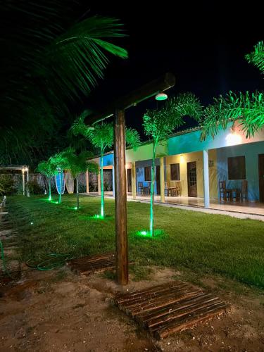 a group of trees with green lights in front of a house at The Jungle, Village & Beach in Guriú