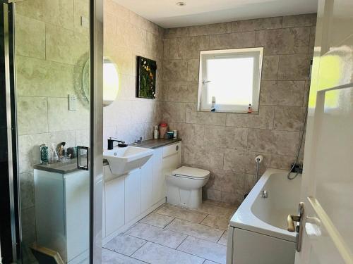 a bathroom with a toilet and a sink and a tub at 4-Bed Seaside Dream House - Sleeps 8 & Parking in Dundee