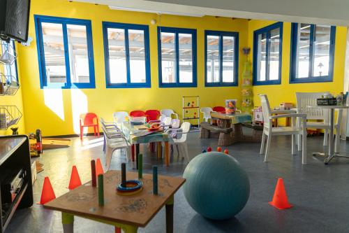 a classroom with tables and chairs and a large ball at Kefalos Damon Hotel Apartments in Paphos City
