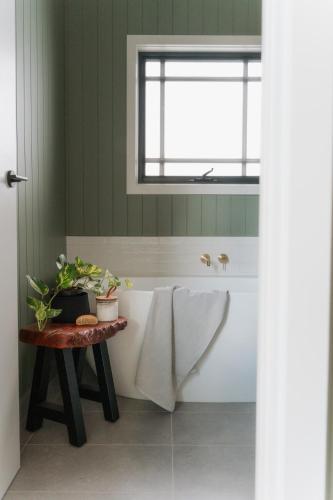 a bathroom with a bath tub and a window at The Barn - On Cockatoo Lane in Sandy Creek
