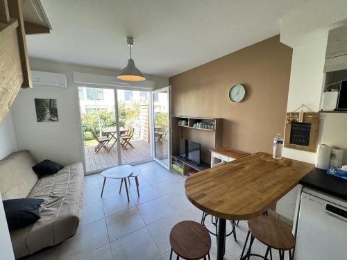 une cuisine et un salon avec une table et des chaises dans l'établissement Valras-Loc La Dune - Brise Marine Elegance Cotiere, à Sérignan