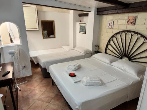 a room with two beds and a couch and a mirror at B&B Baia di Riaci Tropea in Santa Domenica