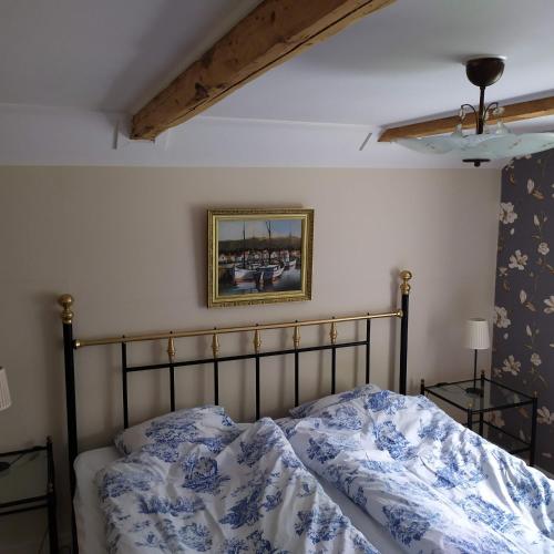 a bedroom with a bed with a blue and white comforter at Bli en del av Vråka by in Edsbruk