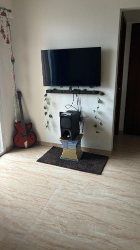 a tv on a stand with a speaker in a room at Stylish Flat at 21st Floor in Kharadi