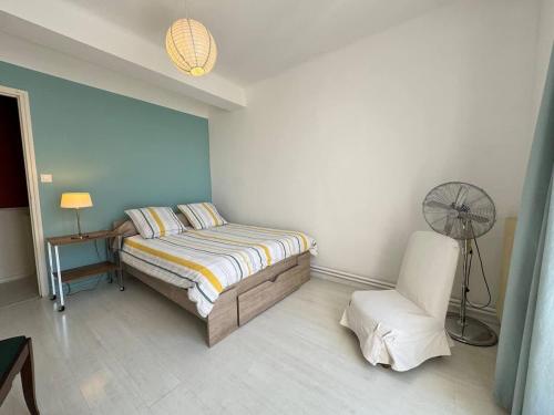 - une chambre avec un lit, une chaise et un ventilateur dans l'établissement Charmant T3 en centre ville Beziers avec parking, à Béziers