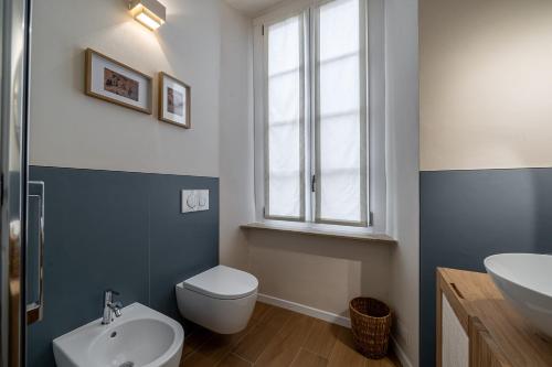 a bathroom with a white toilet and a sink at Borgo delle Botteghe Luxury Suites in Parma