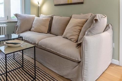 a white couch in a living room with a table at Borgo delle Botteghe Luxury Suites in Parma