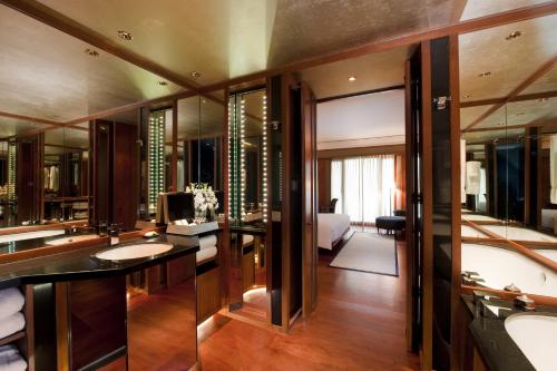 a bathroom with two sinks and a large mirror at The Sukhothai Bangkok in Bangkok